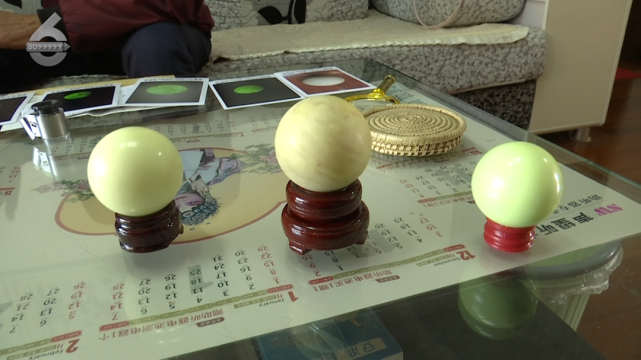 洪先生从网上买来了不同价格不同颜色的人工合成夜明珠作对比后,发现