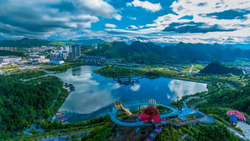 手托人花丛和太阳映衬下的流水长桥整洁宽阔的景区门口杉木湖园区part