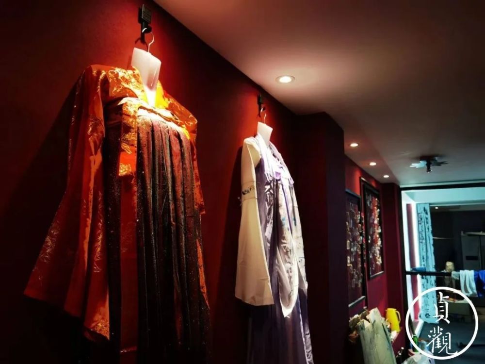 簇新的招牌设计成古风式样,玻璃橱窗里全是各色材质款式的汉服,琳琅