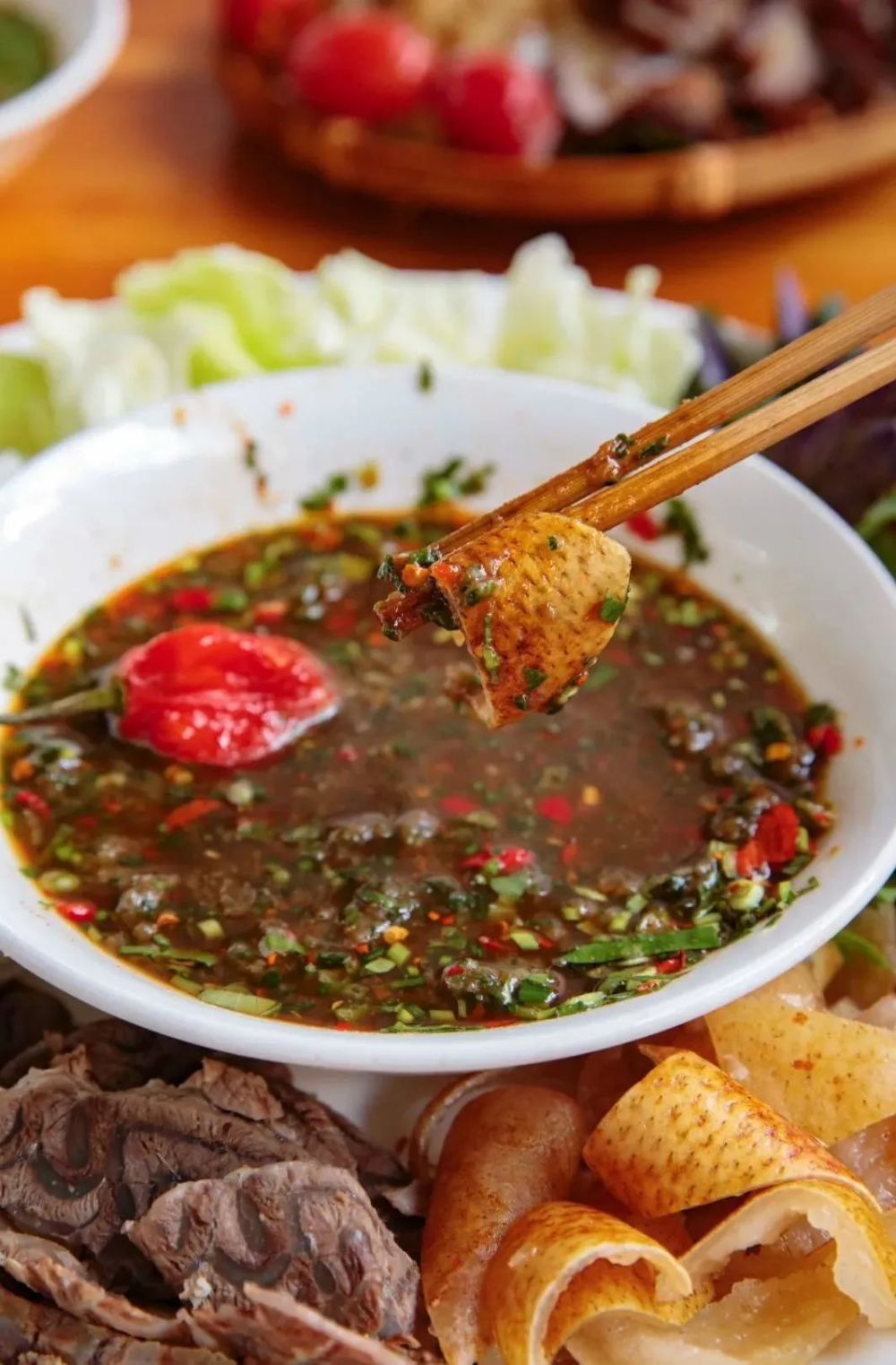 撒撇是将生肉捣烂成泥,放上韭菜,香柳,缅芫荽,小米辣,涮涮辣等佐料,再