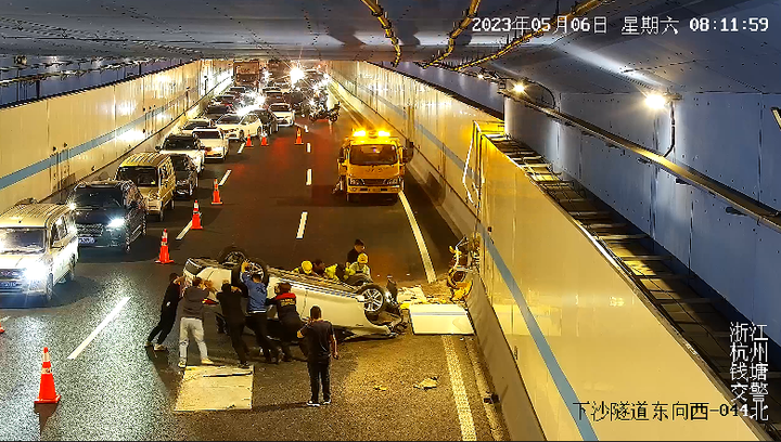杭州市钱塘区下沙隧道里，一辆白色轿车“四脚朝天”。
