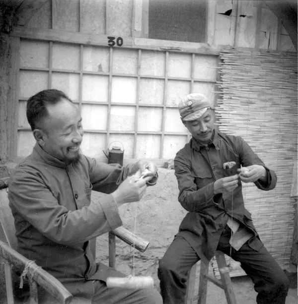 1942年,晋察冀边区参议会副议长于力(左),高等法院院长王斐然捻毛线