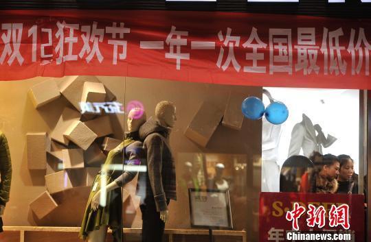 图为一服装店挂着"双12"活动横幅(陈超 摄)