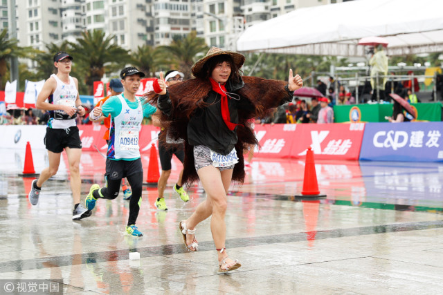 轮椅选手大雨中跑马拉松蓑衣大神穿凉鞋奔跑