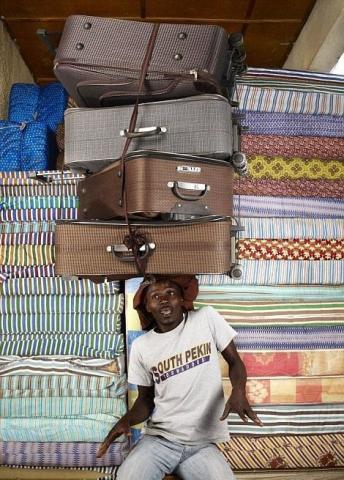 全球多地居民头顶重物炫神技有人可顶4个行李箱