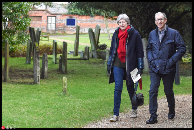 特蕾莎-梅与丈夫现身教堂礼拜 弯腰逗狗豹纹运动鞋亮了