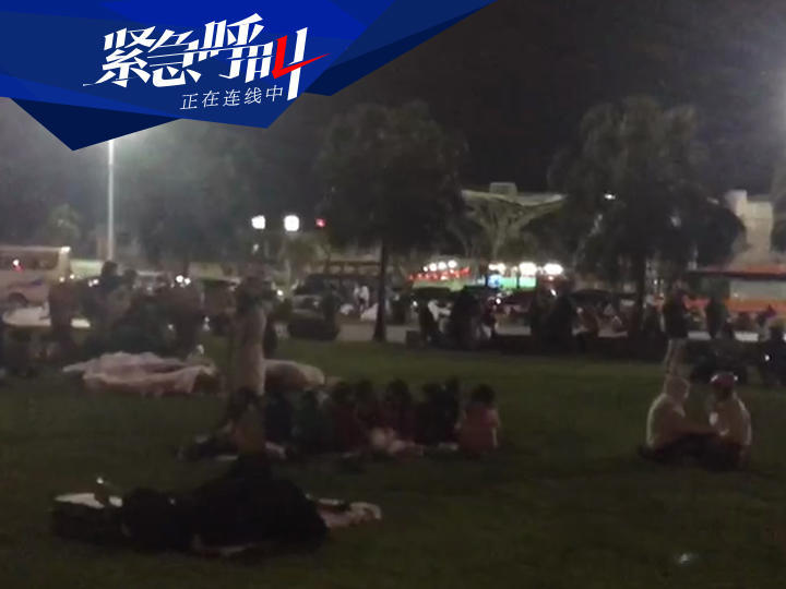 花蓮火車站附近，大量居民聚集在草坪上避難。