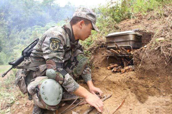 战士在野外利用简陋条件埋锅造饭.