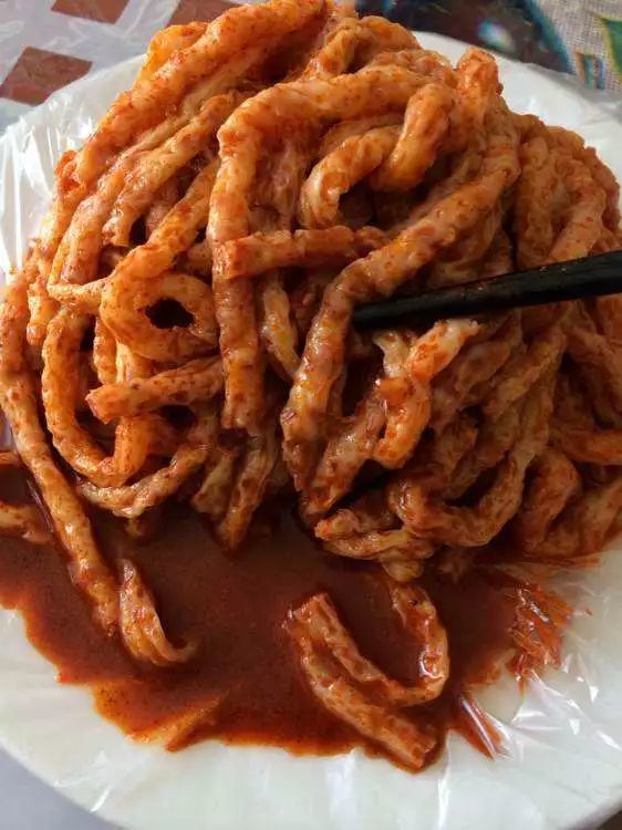 通渭牛筋面,切成长条,配上面筋,浇上醋,辣油,蒜 泥等佐料,吃起来辛辣