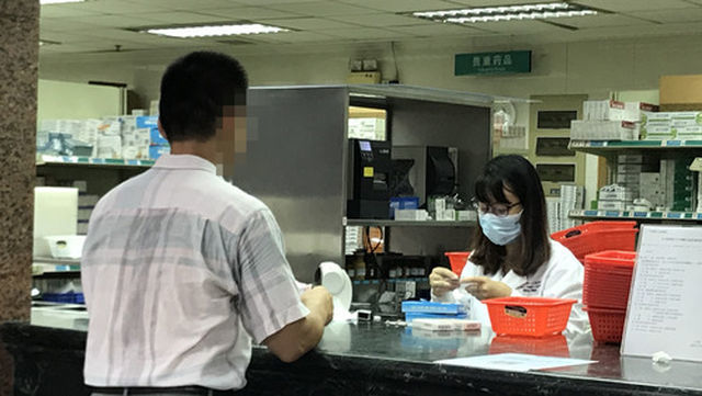 7月19日下午，患者在广州市第一人民医院药房取药。新华社记者 胡林果 摄