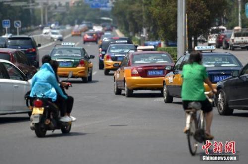 资料图：在路上行驶的出租车。 中新网记者 金硕 摄