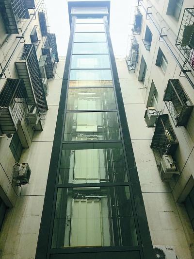 昔日垃圾道变身电梯井 老楼装电梯又有新创意