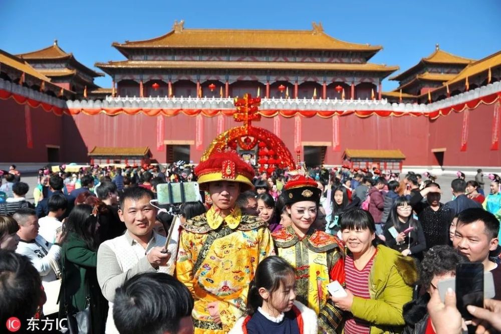 横店影视城明清宫苑内清代宫廷大巡游，游客围堵“皇帝”合影。 在宫廷戏红火的年代，横店影视城明清宫苑是以北京故宫为原型，按1：1比例兴建的一座特大型景区。图片 | 东方IC