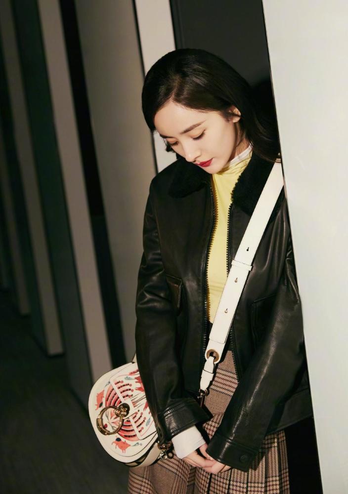 杨幂不受风波影响,皮衣半身裙打扮似少女,斜挎