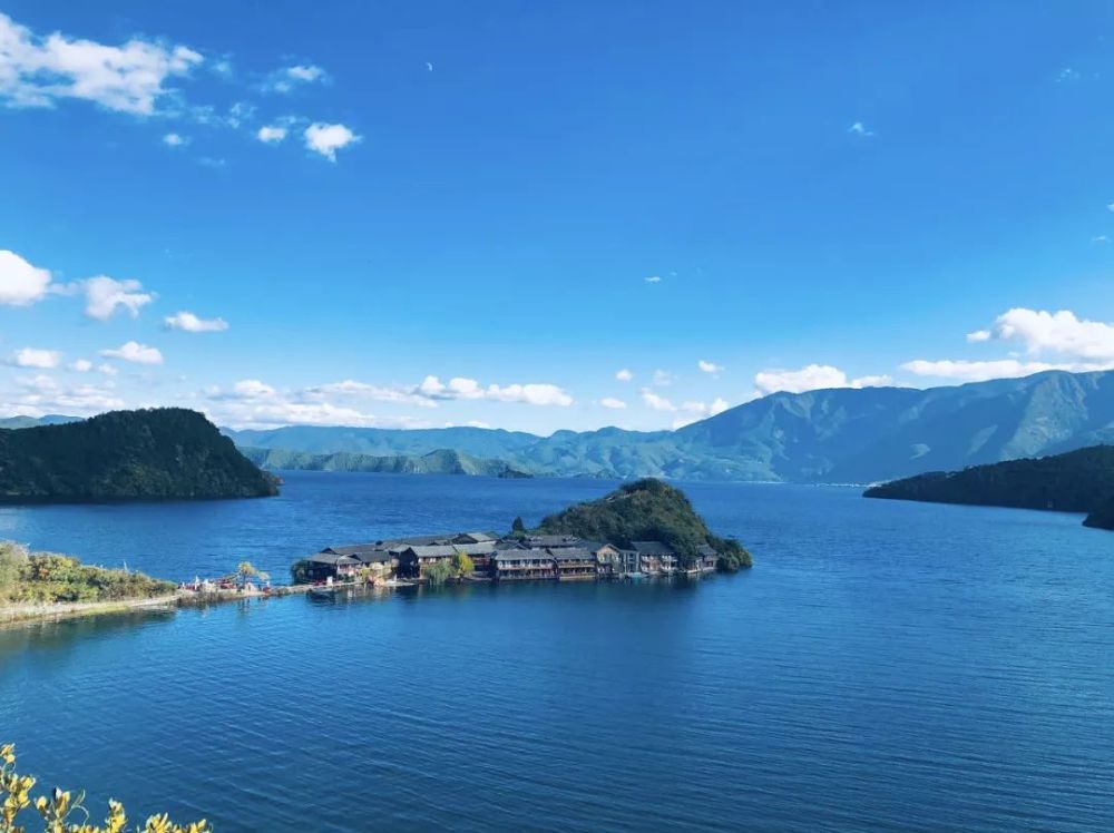 穿過硃紅的木橋,站在瀘沽湖的觀景臺上,眼前水天一色,湖水波瀾不驚