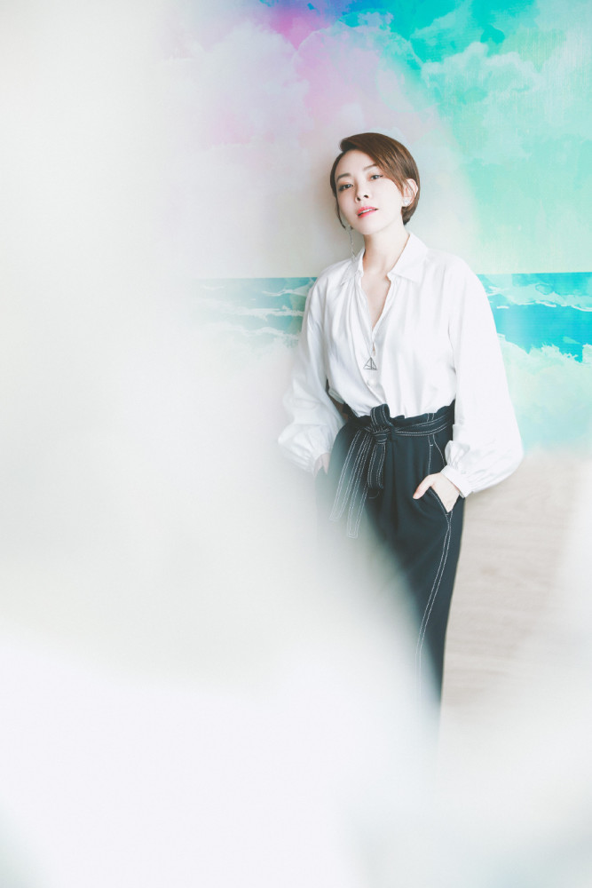 剧中饰演马丽的小姨,穿白衬衣配高腰休闲裤,戴