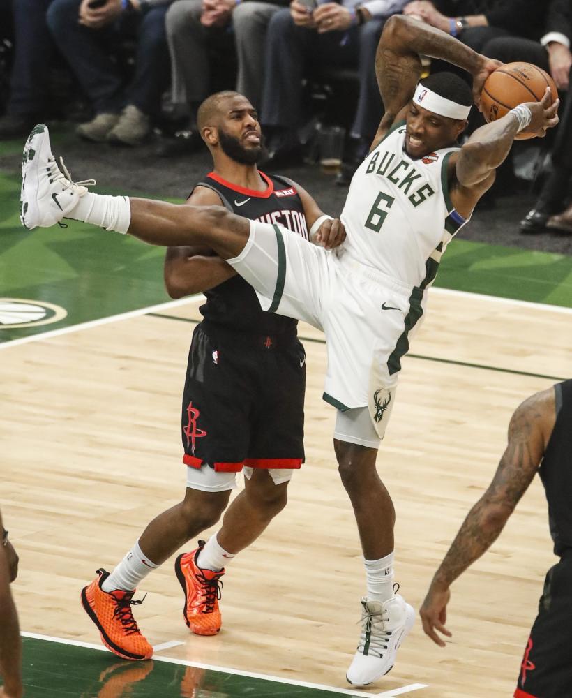 图为火箭队球员克拉克(上)与雄鹿队球员米德尔顿在比赛中拼抢.