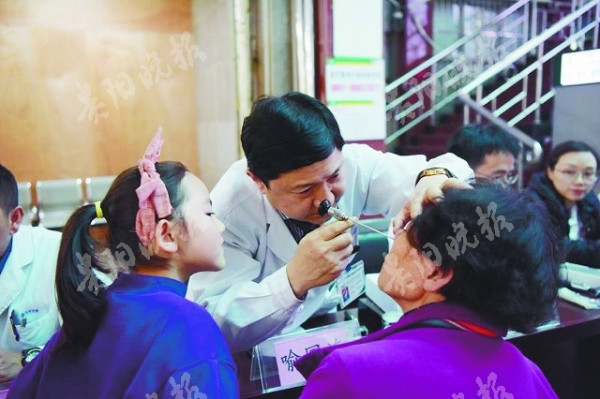 医生为市民检查鼻孔春暖花开是各类鼻炎的发病高峰期,贵医附院耳鼻咽