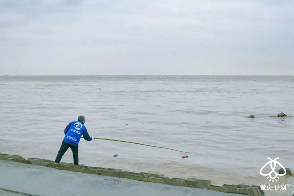 仁渡海洋创始人刘永龙正在海边捡垃圾