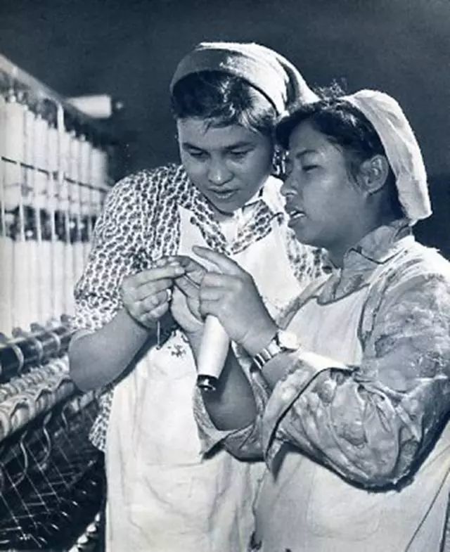 1965年,李素兰(右一)在手把手教给喀什勒纺织厂细纱女工拉比叶的先进