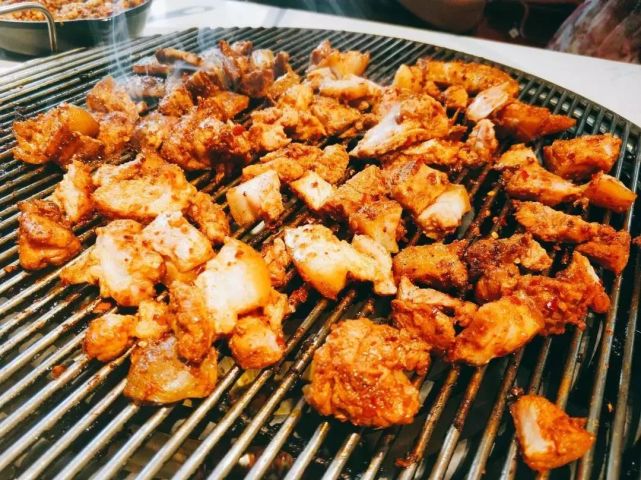 彝家特有的小香猪,宰成大块"坨坨肉"放在钢炭上烤,油滴在炭上发出"