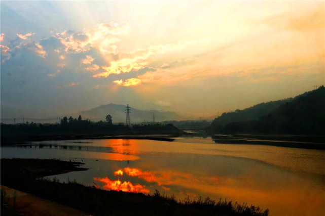 慢慢地,只见潼江河里,天水相接的地方出现了一道红霞.
