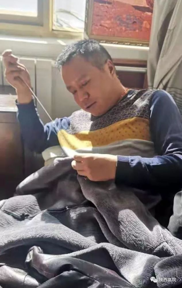 张锋华正在缝扣子