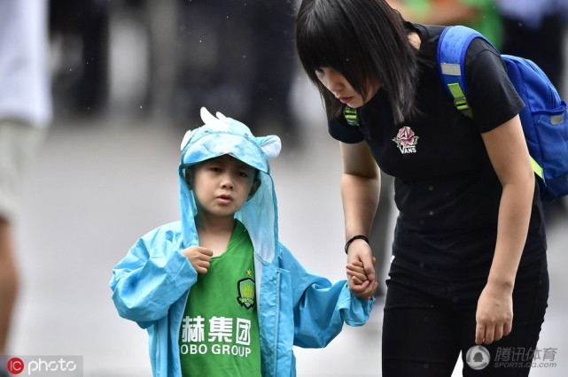 国安球迷小跑避雨 眼镜美女抢镜