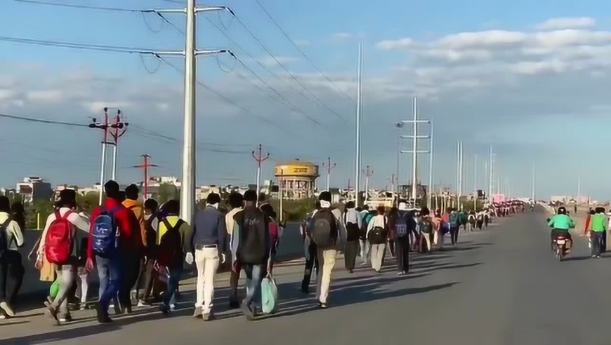 因疫情印度封国,公共交通停运.成群结队的人只能步行回家乡.