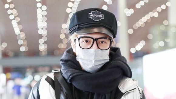 薛之谦现身机场时尚帅气，没想到帽子一摘头发全炸