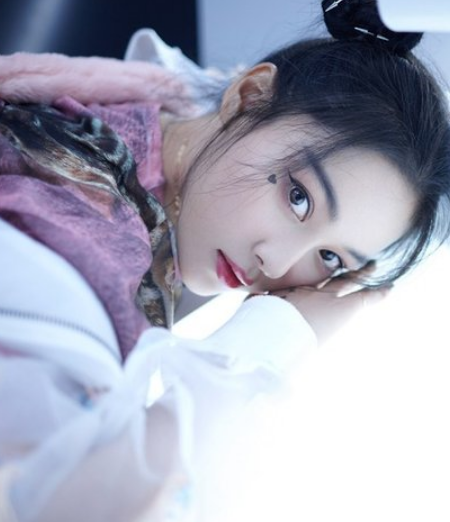 张馨予头扎双丸子头,身着粉色系宽松长裙,可爱不失时尚感