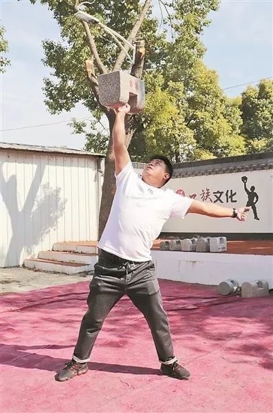 0 2· 许华展示"霸王举鼎 41岁的许华已经练习石锁5年了.
