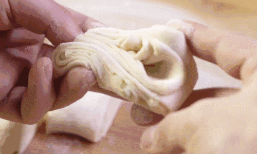 将对折好的面团切成宽度约3cm的小剂子,用一根筷子顺着剂子的长度