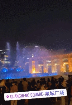 费莱尼夜游泉城广场灯光喷泉前驻足观赏