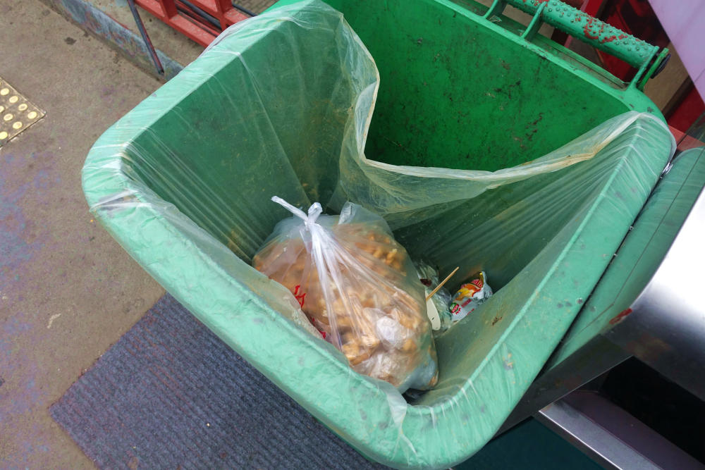 女子给跪地乞丐一袋麻花被乞丐扔进垃圾桶里现场图