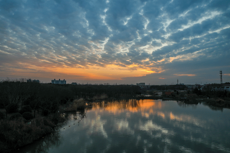 夕阳西下,在天边留下红彤彤的霞光,霞光洒落在宋剑湖平静的湖面上