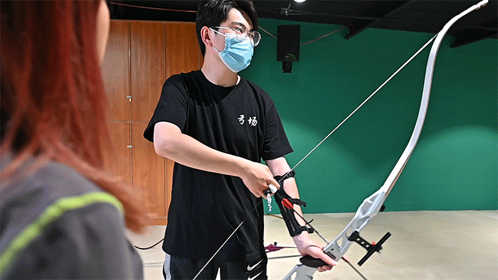 教练会帮忙带好护臂和护指,防止射箭过程中因动作不规范弹伤手臂