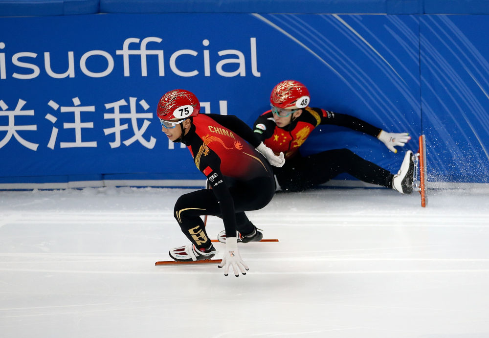 武大靖（右）在比赛中摔倒后，队友孙龙与他击掌接力。新华社记者 曹灿 摄