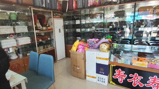 "做殡葬生意的胡秀秀店铺里整整齐齐摆放着各种殡葬用品,货架上一排排