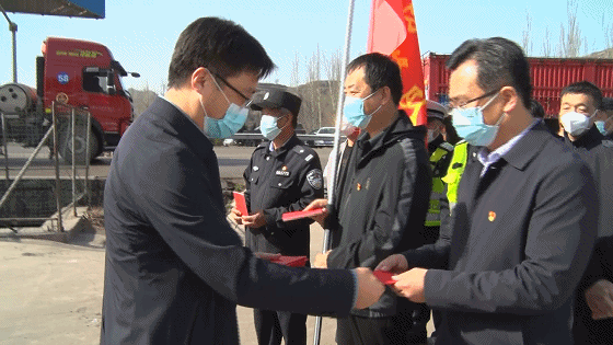 慰问活动中,县长李刚为坚守在各卡口的疫情防控人员发放了党章,县委