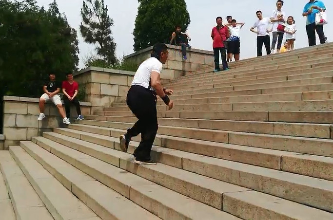 济南英雄山, 尹作平今年57岁,今天挑战的绝活是在52个台阶倒着跑下来