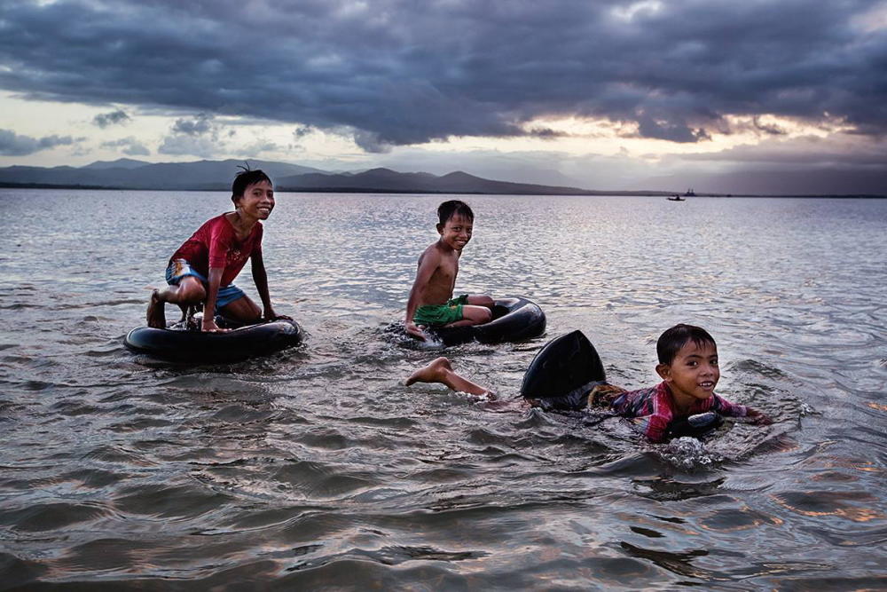 图:菲律宾儿童在水中嬉戏6月至10月是菲律宾的雨季,连续数日大雨后
