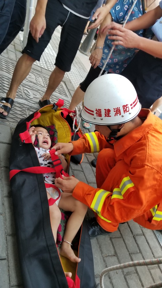 了看热闹的人群,透过居民楼的窗子可明显看到躺在二楼平台上的儿童