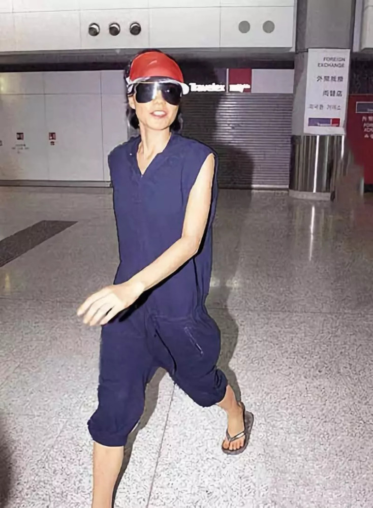王菲还会穿这种运动款的无袖连体裤出入机场,搭配人字拖,非常嗽性