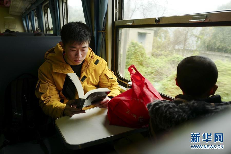 1月31日,一名乘客在5612次绿皮"小慢车"上看书. 新华社记者 刘潺 摄