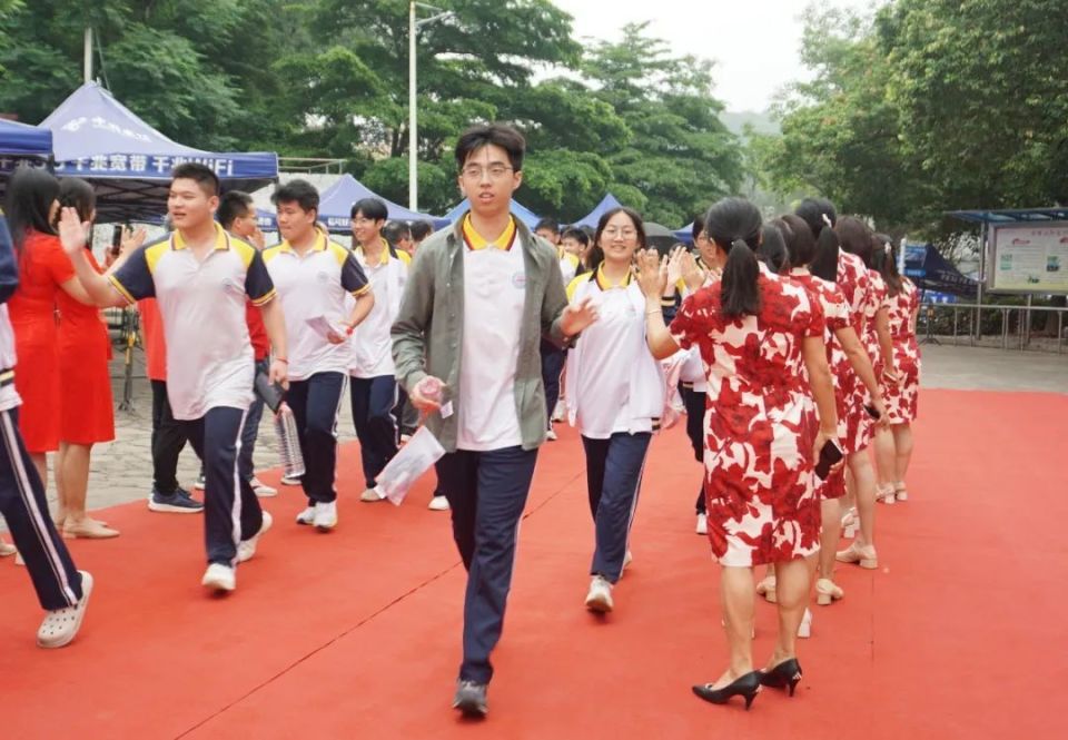 在江门市棠下中学考点,考生与老师击掌后自信步入考场.
