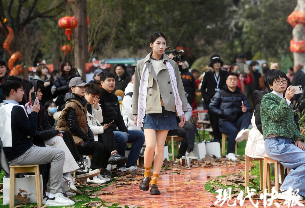 以绿植布置秀场,以落叶为t台,当身着小熊猫元素服饰的模特一一走过时