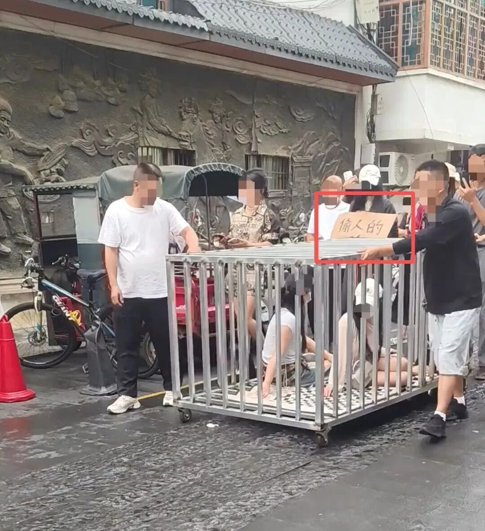 “浸猪笼”重现街头？两女子和狗被关笼游街、挂“偷人的”牌子_腾讯新闻