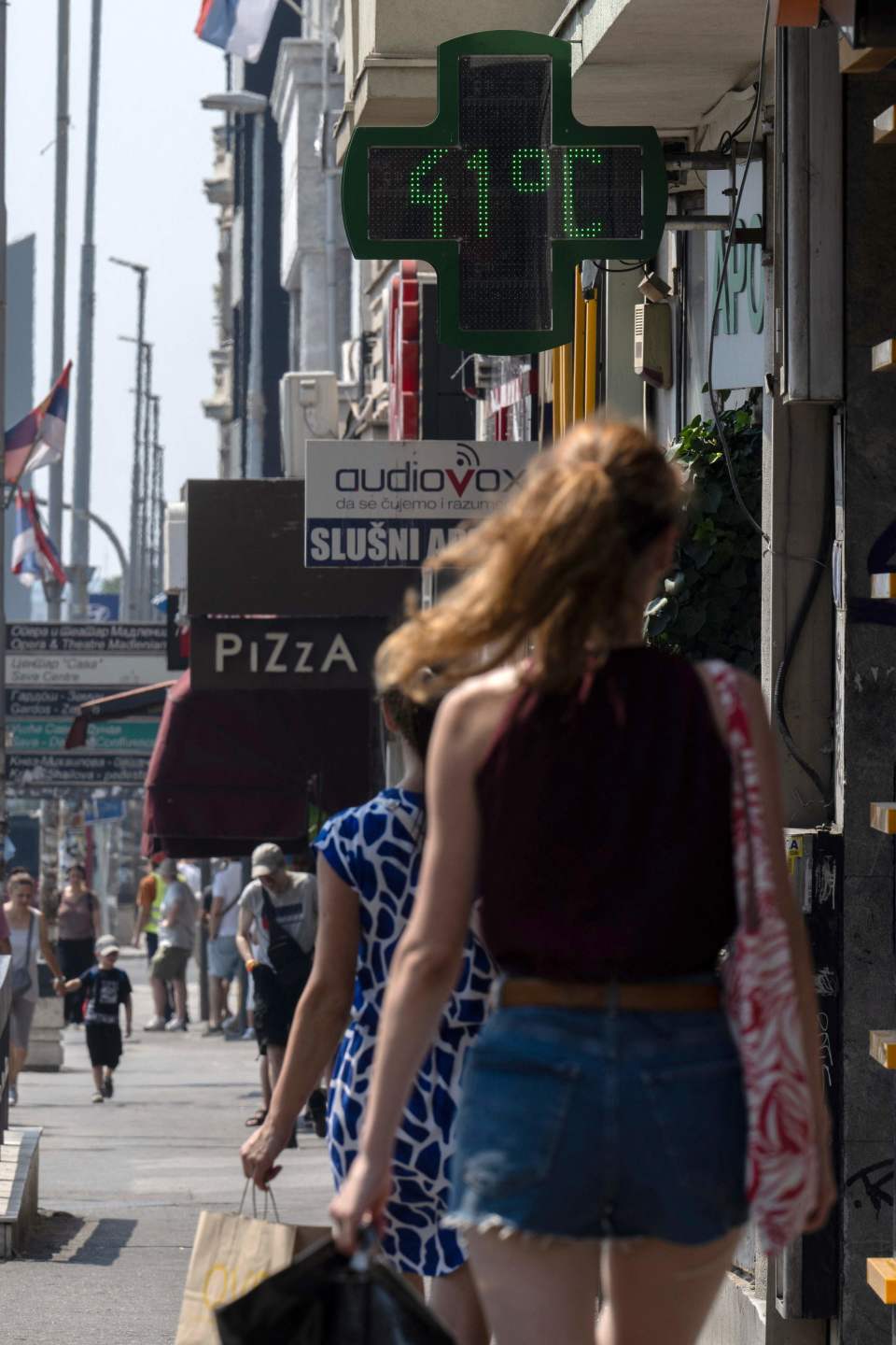 新华社/法新7月13日,在塞尔维亚贝尔格莱德,行人经过街头的温度计.