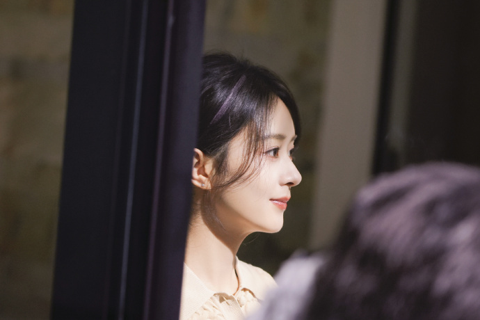 画面中的赵丽颖也穿着米黄色的针织上衣,一头柔顺的长发也被她盘起